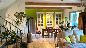 A spacious living area with a staircase, a dining table, and a sofa. - Charming house with swimming pool, garden, 8 min from Aix-en-Provence, near the Golf course (Aix-en-Provence)