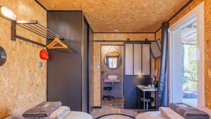 Una habitación con dos camas, un espejo, un lavabo y una ventana.