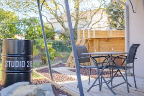 A patio with a table and chairs, a barbecue grill, and a wooden fence. - Guest Room '315' with Mountain View, Private Heated Pool, and Wi-Fi (Villeneuve-de-Berg)