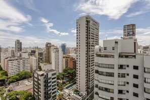 A high-rise building with multiple floors, surrounded by other buildings and greenery. - Your Urban Retreat Near the Subway - Iby1613 (São Paulo)