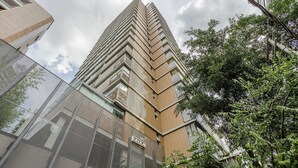 A modern high-rise building with a prominent corner design, large windows, and a visible address sign. - Your Urban Retreat Near the Subway - Iby1613 (São Paulo)