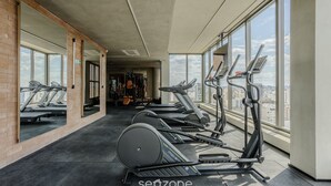 A gym with treadmills, exercise bikes, and a mirrored wall. - Your Urban Retreat Near the Subway - Iby1613 (São Paulo)