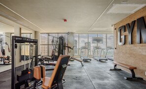 A gym with exercise equipment, a bench, and a large 'GYM' sign on the wall. - Your Urban Retreat Near the Subway - Iby1613 (São Paulo)