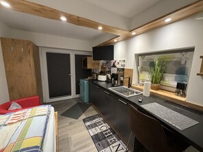 A modern kitchen with a built-in oven, a sink, and a window with a view of greenery. - NEW! Apartment Engel (Weilburg)