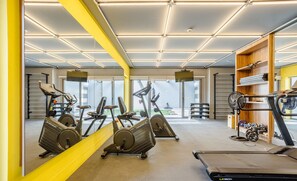 A gym with exercise equipment, a treadmill, and a fan. - Complete Stay With Pool and gym Steps From the Metro in Pinheiros - SP - LOF (São Paulo)