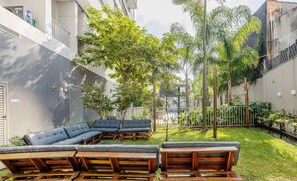A courtyard with outdoor seating and trees. - Complete Stay With Pool and gym Steps From the Metro in Pinheiros - SP - LOF (São Paulo)