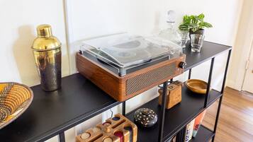 A wooden shelf with a vintage radio, a glass container, a small plant, and decorative items.