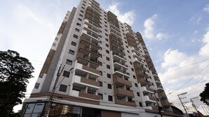 Een hoog appartementencomplex met meerdere balkons en een modern architectuur.