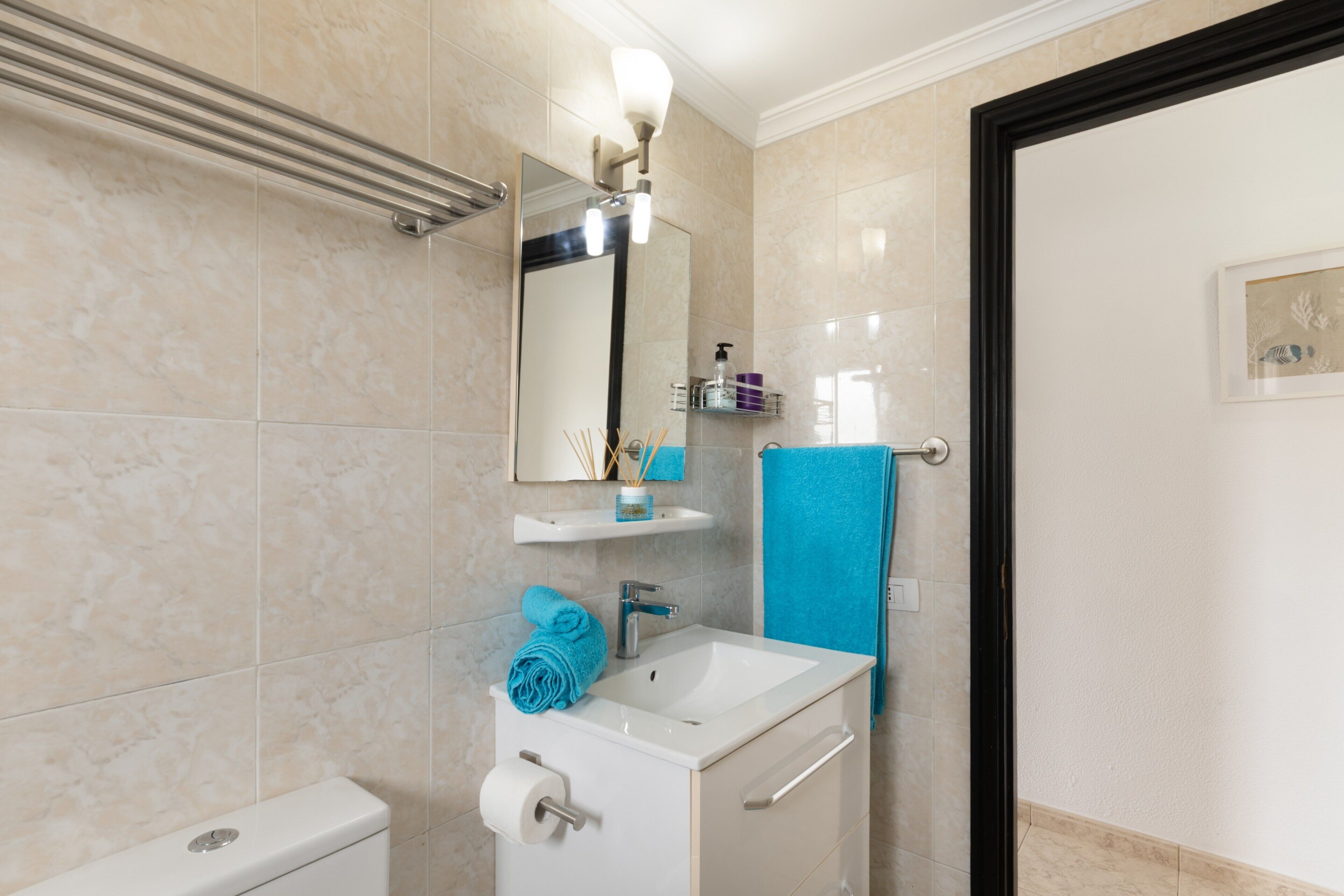 Ein Badezimmer mit Waschbecken, Spiegel und Handtuchhalter.