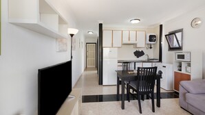 A modern apartment with a dining area, kitchen, and living space.