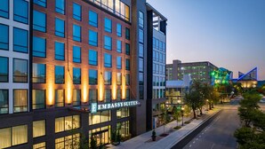 A modern hotel with a prominent 'Embassy Suites' sign, large windows, and a well-lit facade. - Embassy Suites By Hilton Chattanooga Downtown (Chattanooga)