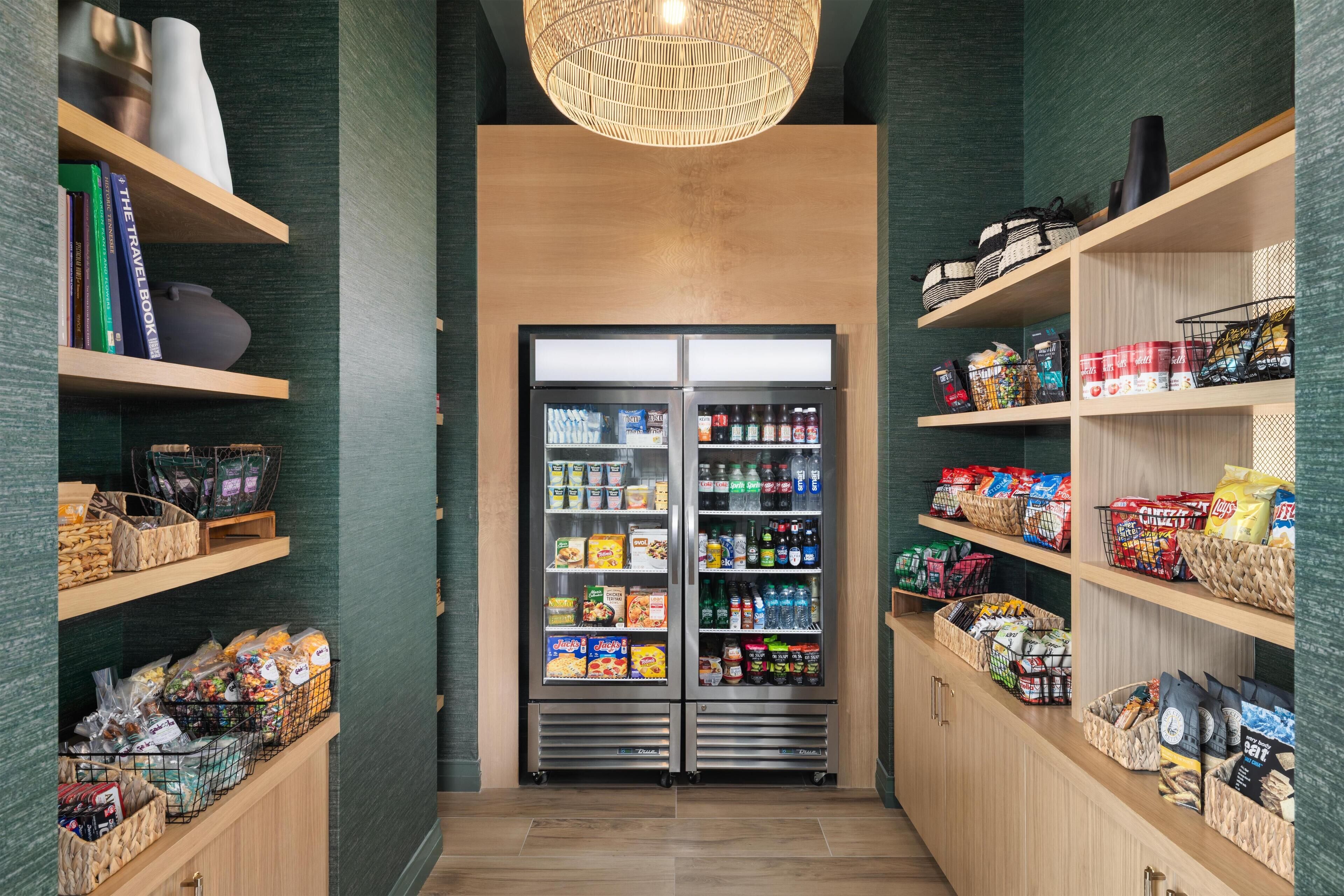 Een gang met een automaat voor snacks en planken vol met snacks en drankjes.