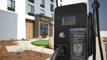 An EV charging station with a QR code and instructions for use.