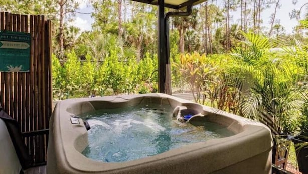 A hot tub with a view of tropical vegetation. - Poolside Paradise/Suite Serenity: in Naples, FL (Naples)