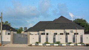 Una casa moderna de dos pisos con entrada portonada, techo inclinado y unidades de aire acondicionado.