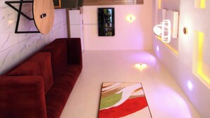 Un interior moderno con un sofá rojo, una mesa de madera y un cuadro en la pared.