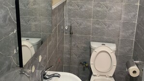 Un baño con lavamanos blanco, inodoro y ducha.