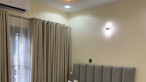 Un dormitorio ordenado con cama, mesita de noche y un equipo de aire acondicionado.