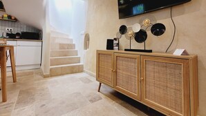 A modern kitchen with a built-in microwave, a wooden dining table, and a staircase leading to an upper level.