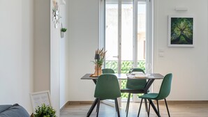A dining area with a table, chairs, and a view through a glass door. - Apartment 'Ingrosso Suites - Green' with Private Terrace, Wi-Fi and Air Conditioning (Castri di Lecce)