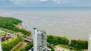 Un paysage urbain côtier avec une étendue d’eau importante, un pont et un grand immeuble à étages.