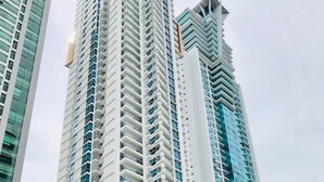 A tall, modern high-rise building with a distinctive zigzag pattern on its facade. - Pacific Cafe Classy 1-bedroom in Costa del Este (Panama City)