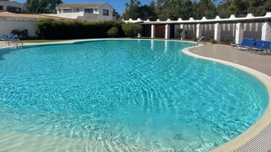 A clear swimming pool with lounge chairs and a covered area. - Relax with the whole family in this quiet and elegant accommodation (Santa Margherita di Pula)