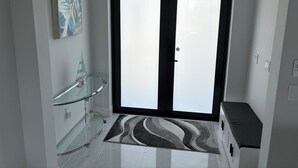 A modern interior with a glass shelf, a patterned rug, and a double door. - Gorgeous, new 3-bedroom, 3 bathroom house. heated Pool in Cape Coral , sleeps 8 (Cape Coral)