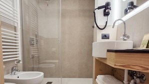 A modern bathroom with a glass shower enclosure, a sink, a bidet, and a vanity with a towel rack. - Il Soffio - Cucina & Camere nel bosco (San Lorenzo Dorsino)