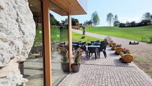 A patio area with outdoor seating and potted plants. - Il Soffio - Cucina & Camere nel bosco (San Lorenzo Dorsino)