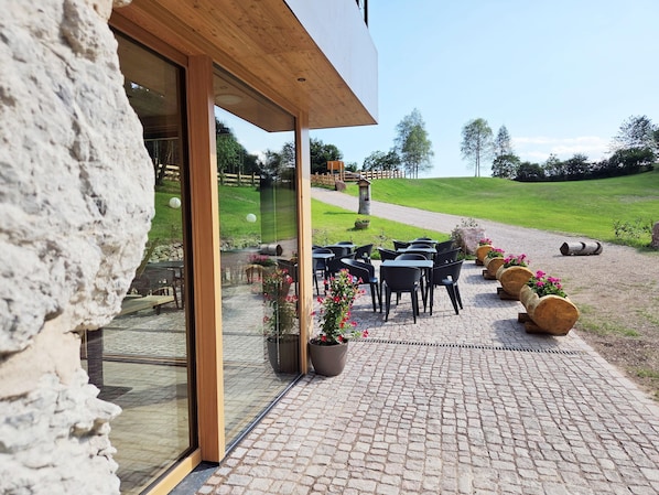 Un patio con mobiliario exterior y plantas en macetas.