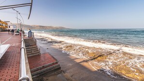 A coastal walkway with steps leading to the beach, overlooking the sea.
