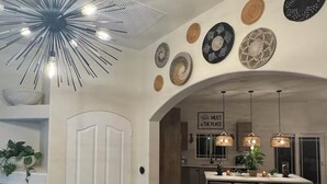 A modern kitchen with a central island, pendant lighting, and decorative plates on the wall. - Welcome to San Diego’s Poway Paradise, your private oasis on Sycamore Canyon! (Poway)