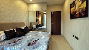 A bedroom with a bed, a wardrobe, a door, and a painting on the wall.