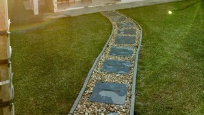 A house with a paved driveway, a lawn, and a patio area with chairs. - Cozy house in Lages, 5 minutes from the pine nut festival. (Lages)