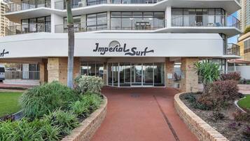 Ein mehrstöckiges Hotel namens „Imperial Surf“ mit modernem Design, inklusive Balkonen und einem begrünten Eingangsbereich.