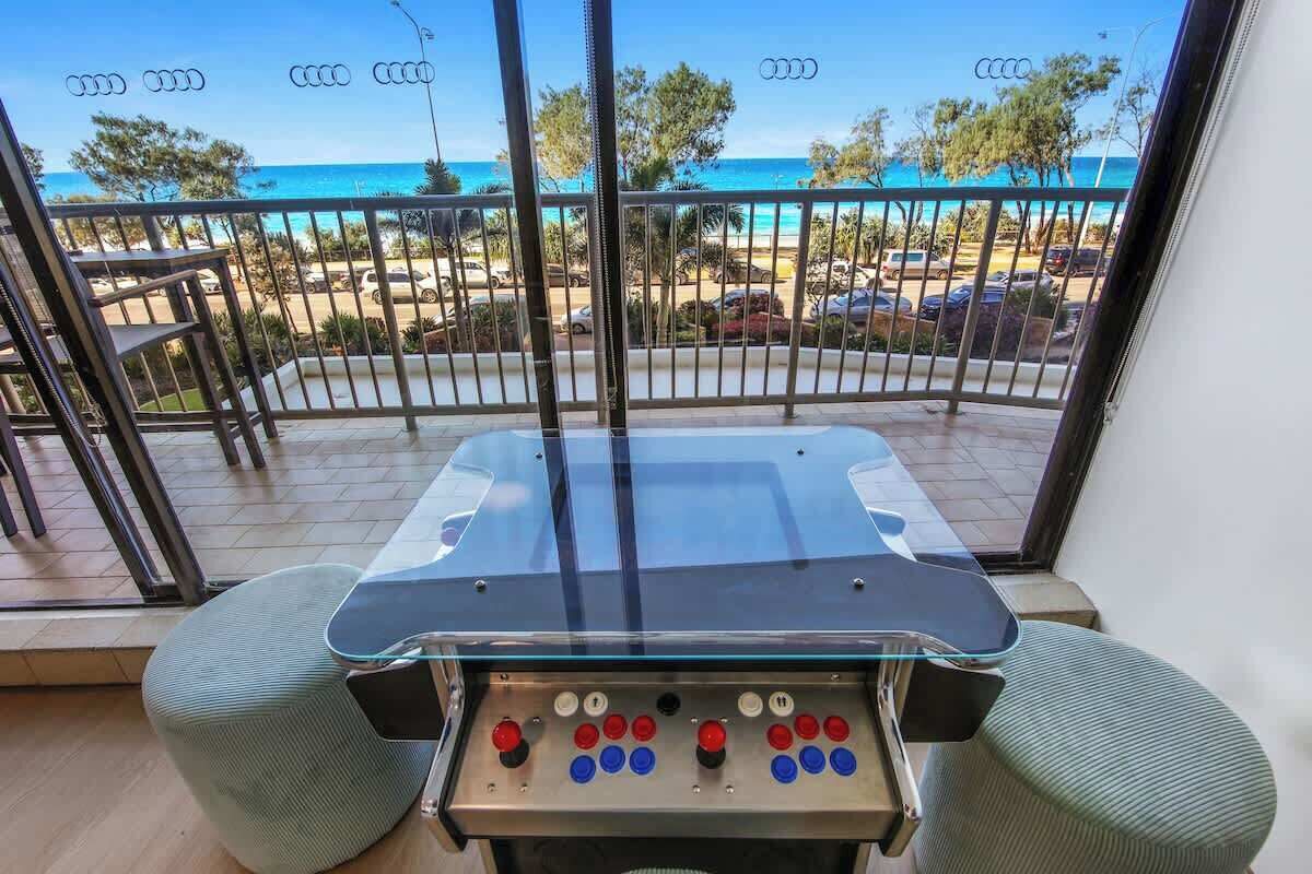 A room with a view of the beach, a pool table, and a control panel.