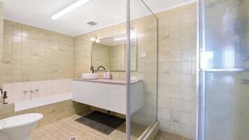 Une salle de bain moderne avec une douche à parois de verre, un lavabo blanc et des toilettes.