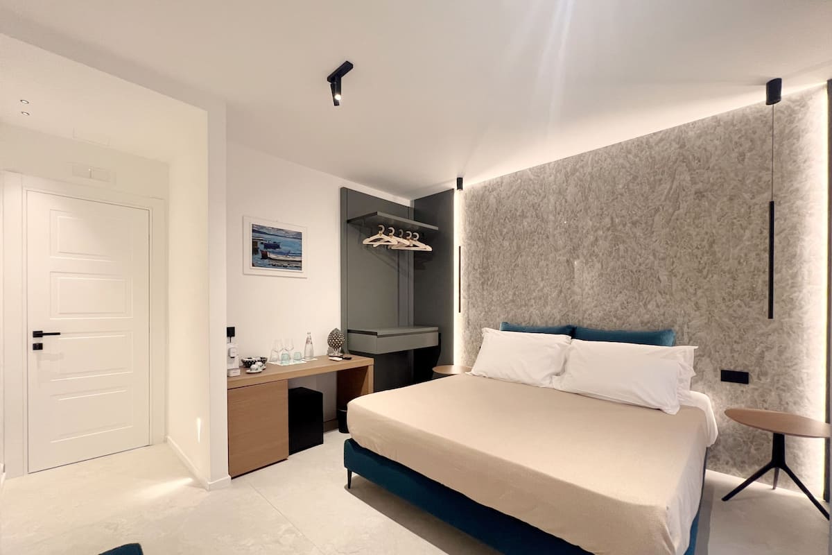 Une chambre moderne avec un grand lit, un bureau et une armoire.
