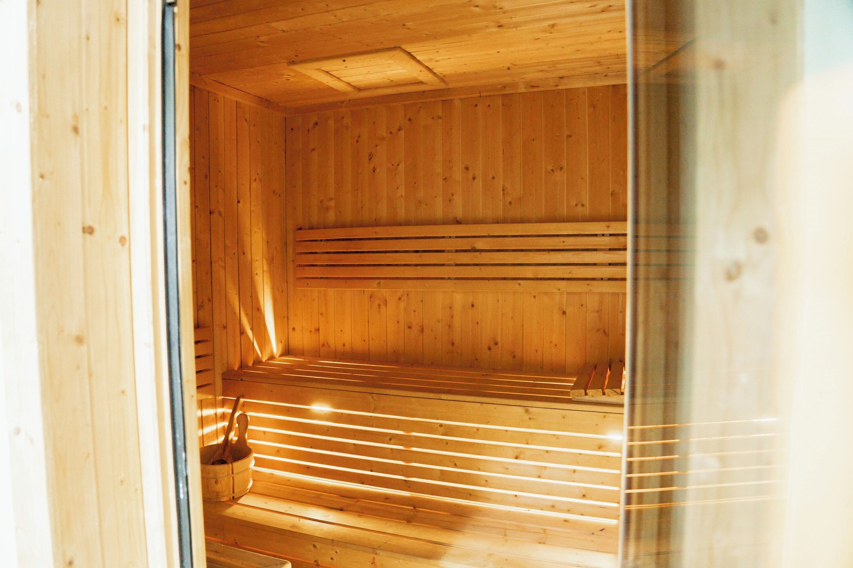 Een sauna met houten banken en een zitbank.
