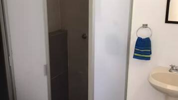 Een douche, handdoeken, zeep, toiletpapier