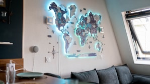 A world map wall art in a room with a dining table, a sofa, and a window. - Mini-duplex NOLEMMA (Deauville) (Deauville)