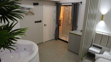 Une salle de bain moderne équipée d’une baignoire, d’une zone de douche et d’un meuble-lavabo avec un miroir.