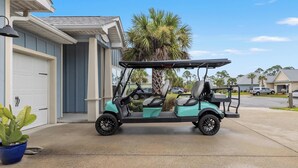 A golf cart parked in front of a house with a garage. - Beach House - Redfish Cove by PHG (Port St. Joe)