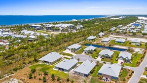 A residential area with houses, a lake, and a beach in the background. - Beach House - Redfish Cove by PHG (Port St. Joe)
