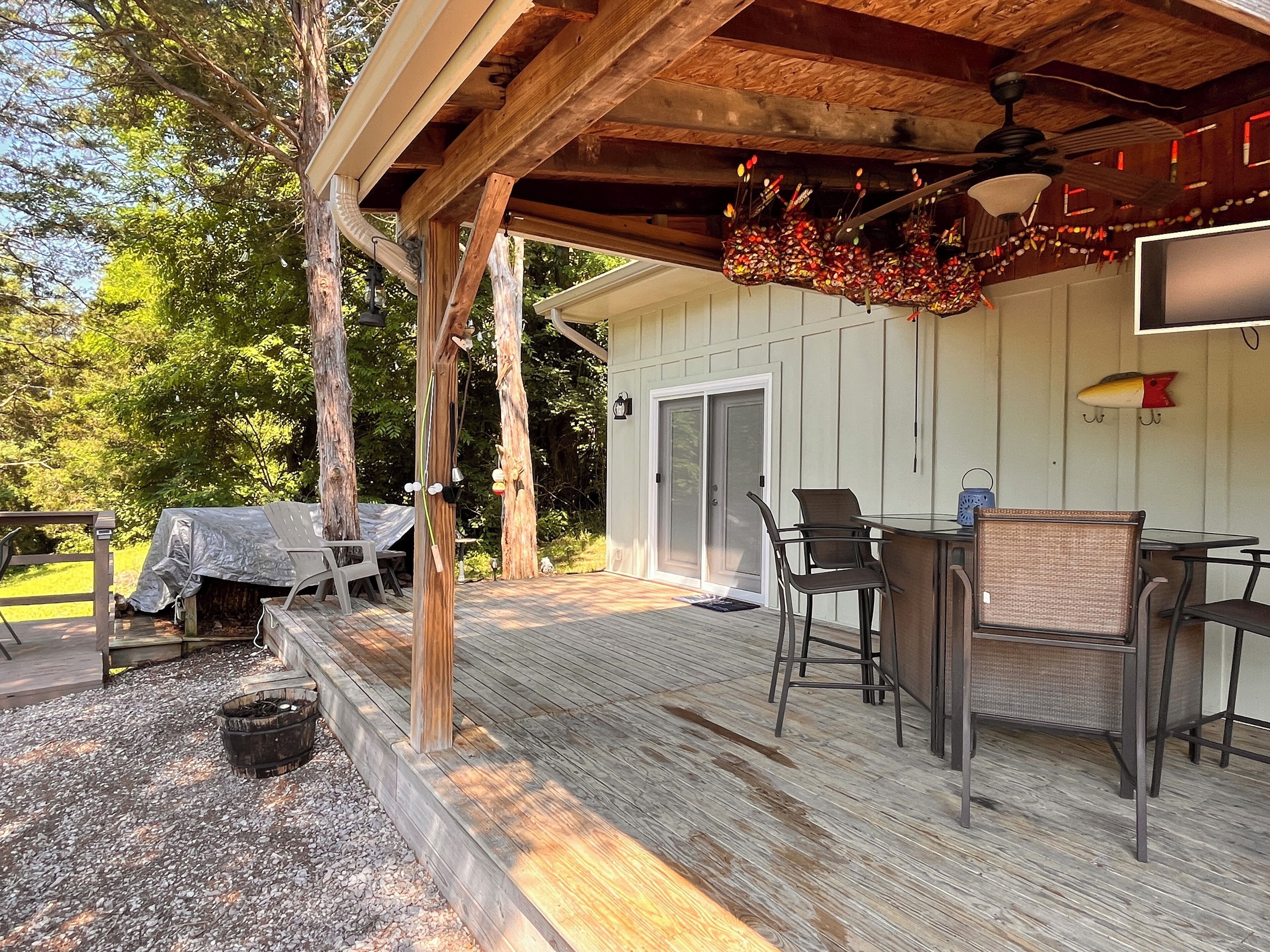 Un patio al aire libre con una zona de estar techada, una mesa y sillas.