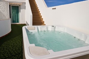 A hot tub with a wooden staircase leading to a door, surrounded by white walls. - ECO Apart comfortable La Orquídea. With terrace, garden and jacuzzi at Green Dharma (Puerto del Rosario)