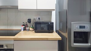 Ett kök med mikrovågsugn, vattenkylare och ett kylskåp i rostfritt stål.