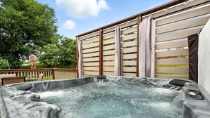 A hot tub with a wooden deck and a fence, surrounded by trees. - Mountain Serenity Retreat - Larkspur Retreat (Larkspur)