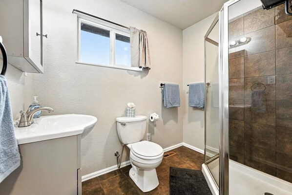 Un baño con inodoro, lavabo y ducha.